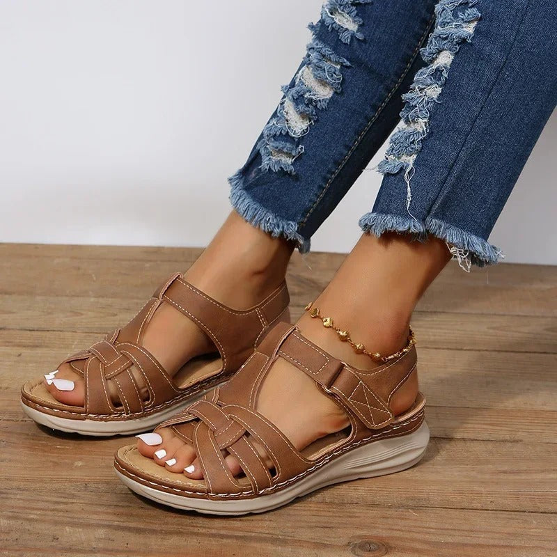 Brown open-toe flat sandals with interlaced cutout upper and back strap