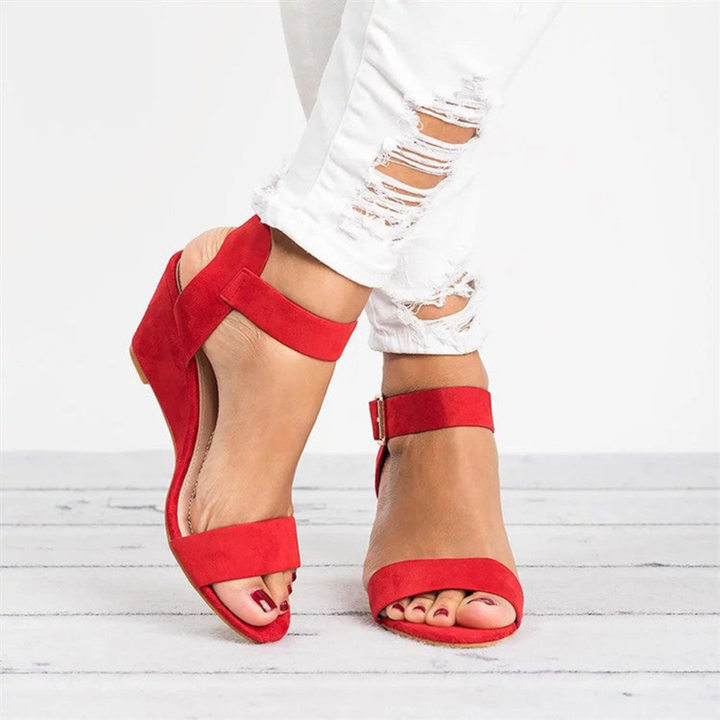 Red open-toe wedge sandals with wide buckle ankle cuff